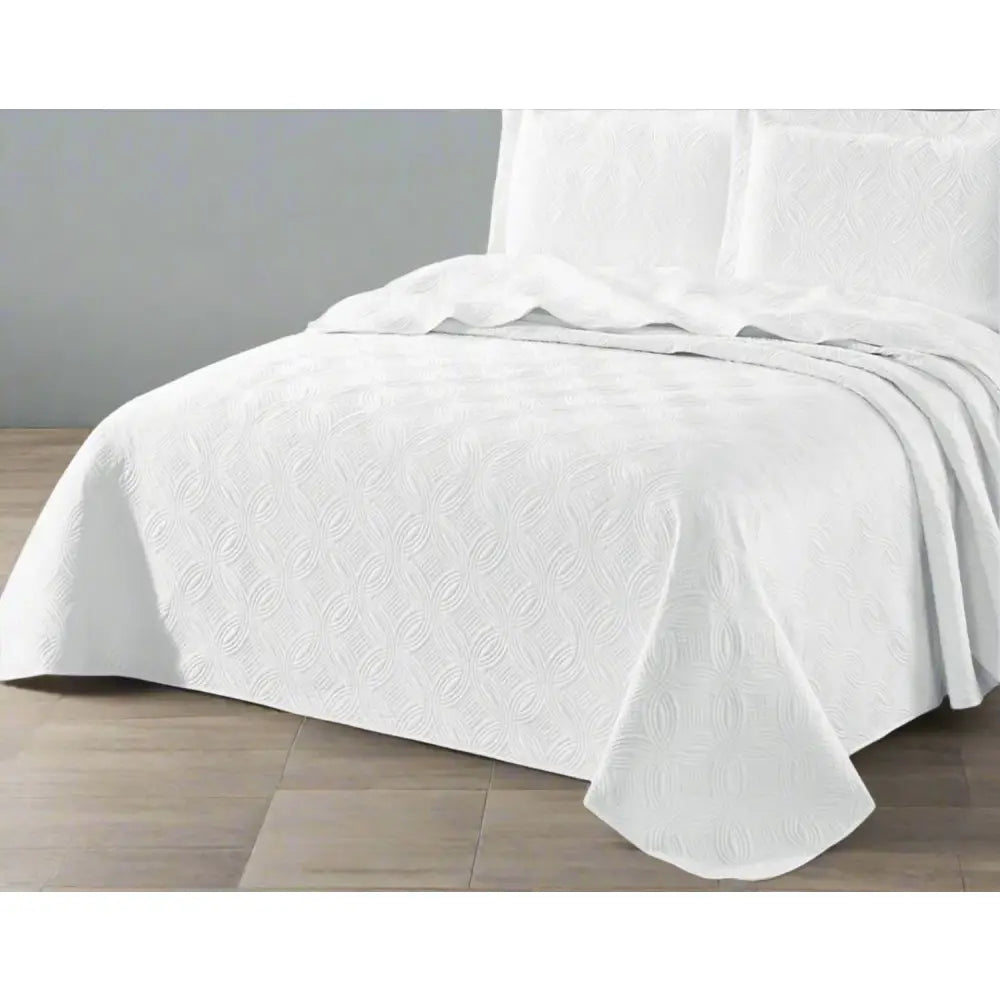 White Munich design quilted bedspread textured bedspread on a bed. 