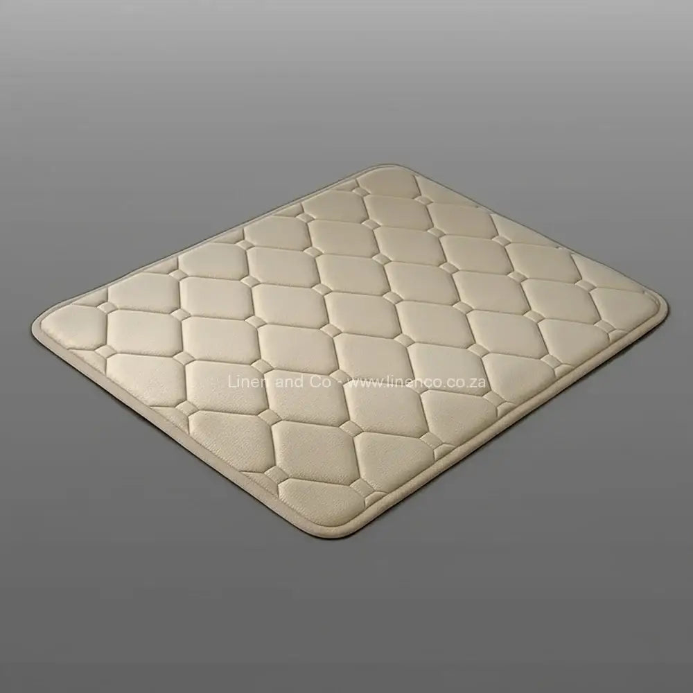 Natural beige memory foam bath mat by Linen & Co on soft grey gradient background, 50x80cm luxury microfibre bathroom accessory with non-slip backing