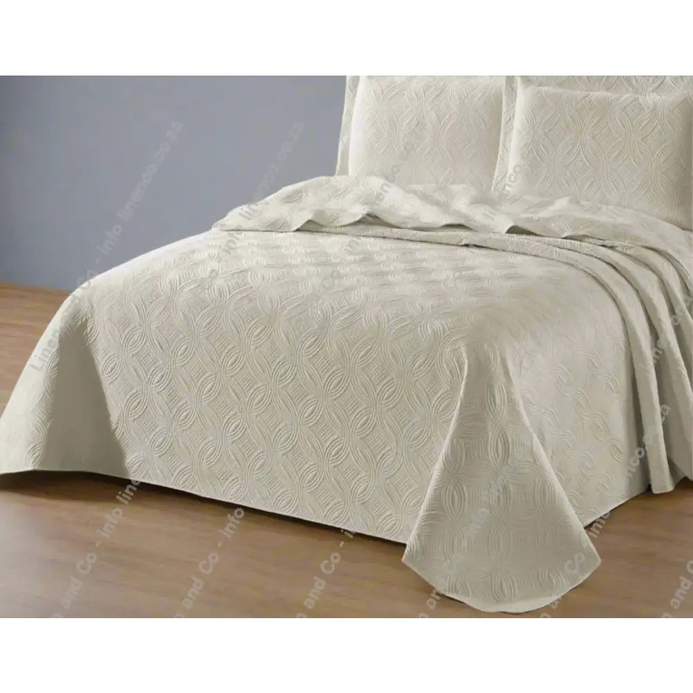 Beige Munich design quilted bedspread textured bedspread on a bed. 