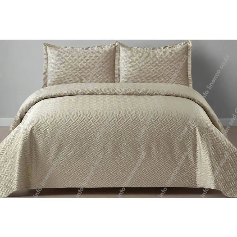 Natural Grey Rome Design Quilted Bedspread set on a bed.
