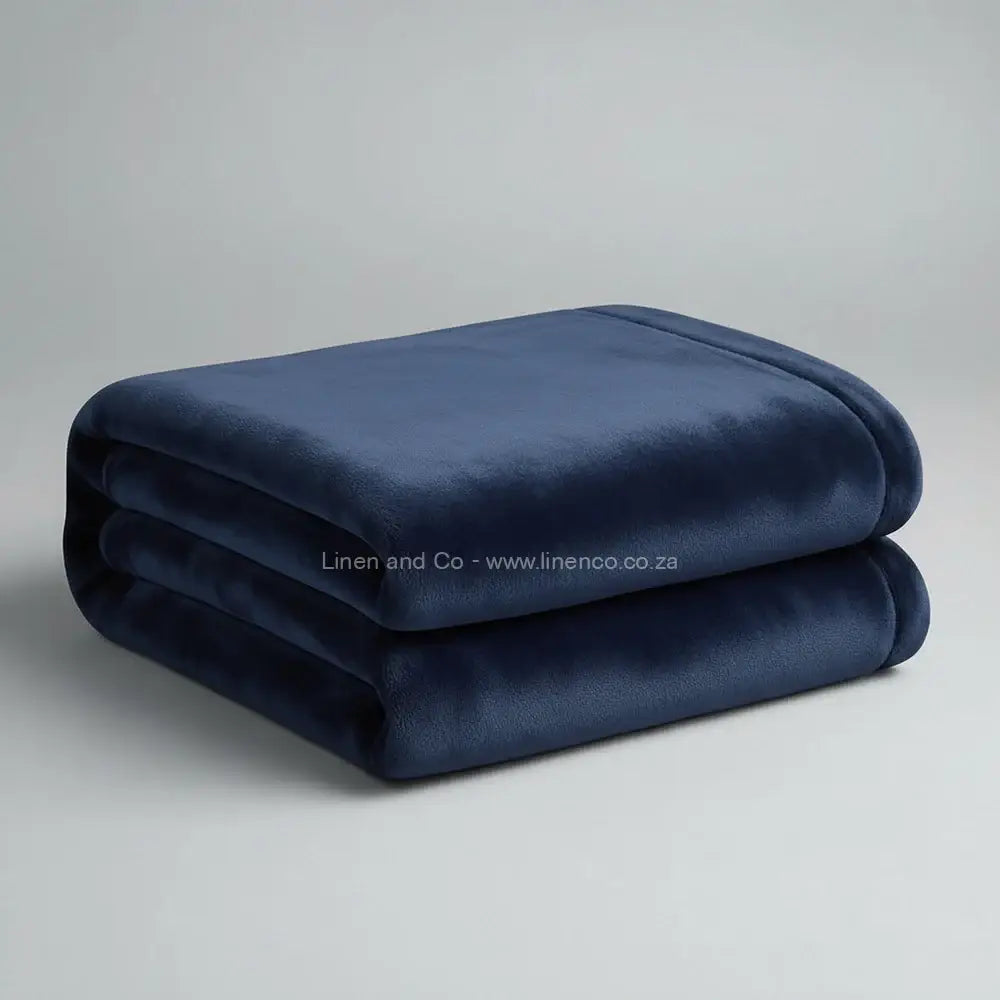 Navy luxury plush blanket neatly folded on light grey background - Linen and Co premium microfibre hospitality blanket