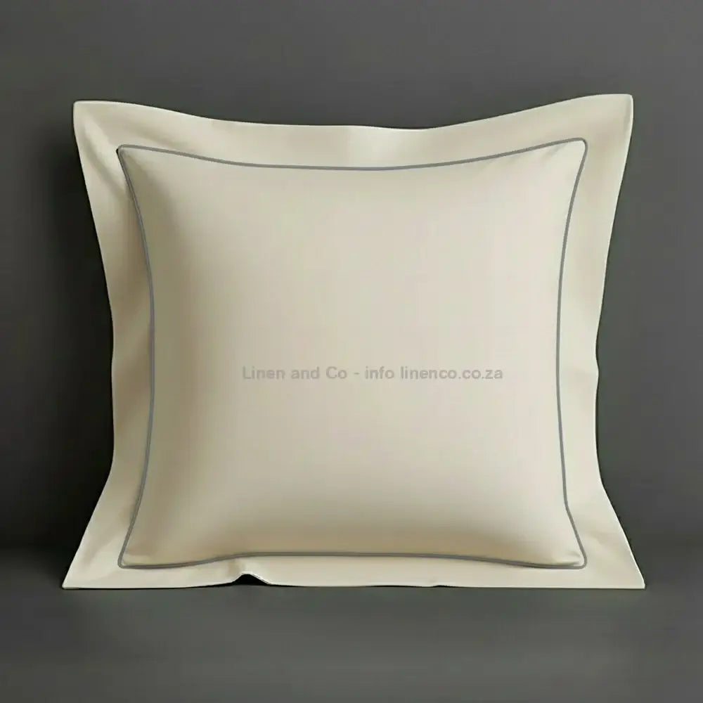 Cream continental oxford pillow case with grey one row satin stitch detail on a grey background. Luxury Hotel Linen by Linen and Co.