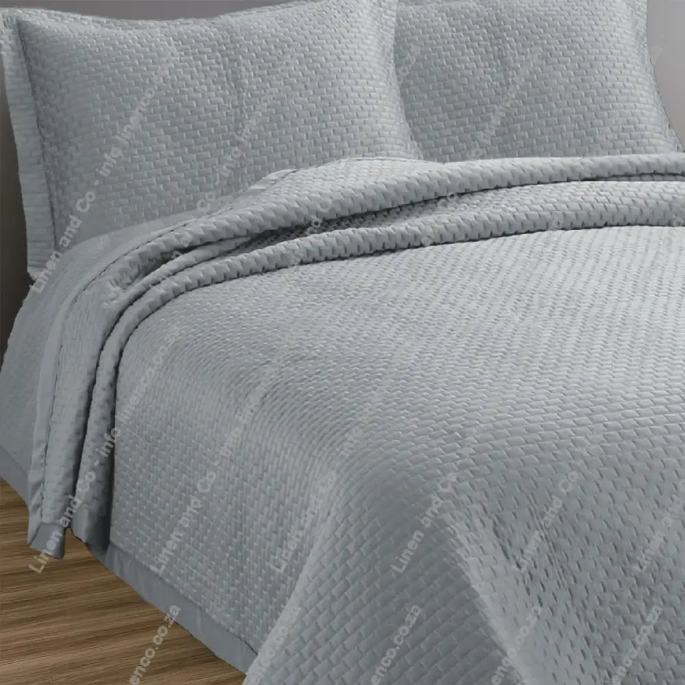 Platinum Berlin design quilted bedspread with matching pillow cases on a bed.