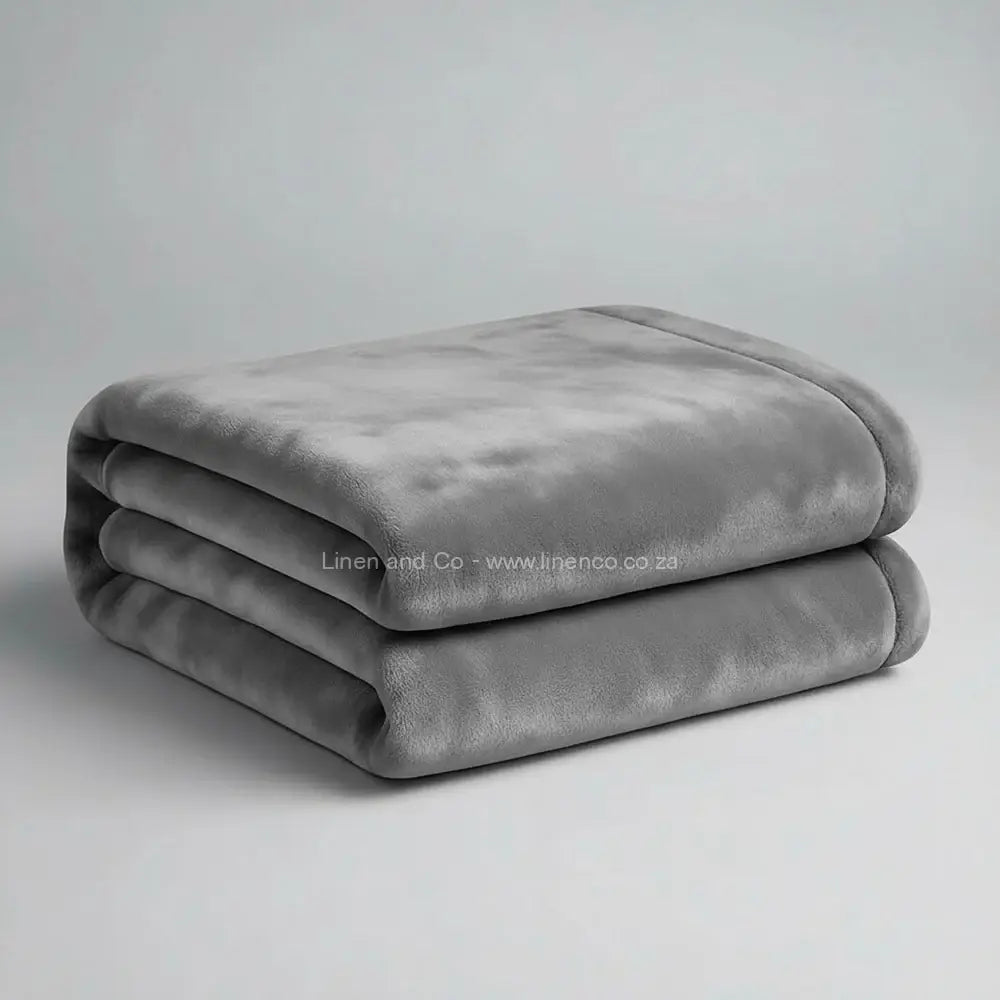 Platinum grey luxury plush blanket neatly folded on light grey background - Linen and Co premium microfibre hospitality blanket