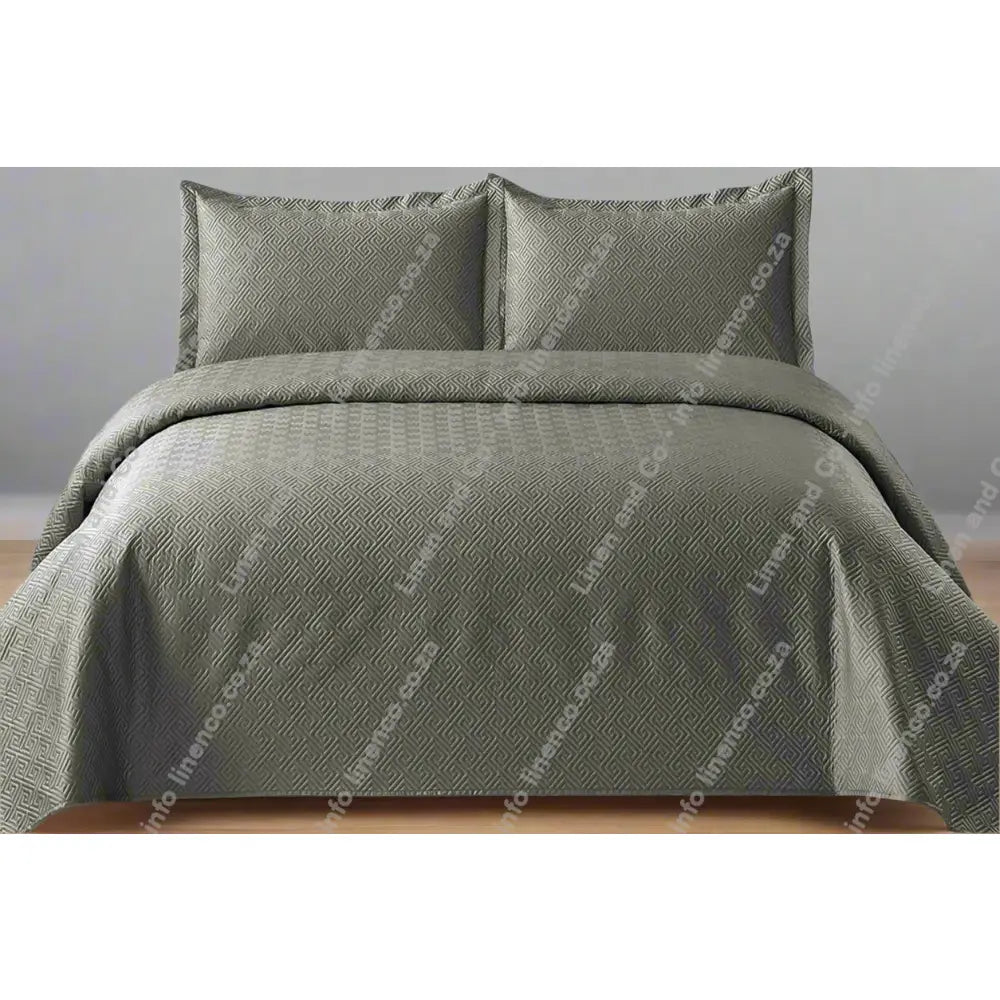 Platinum Grey Rome Design Quilted Bedspread set on a bed.