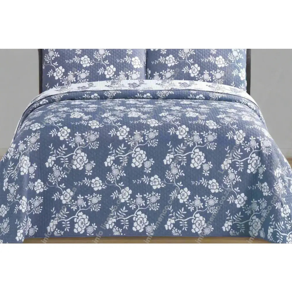 Rochelle Design Floral patterned denim quilt on a bed with matching pillows.