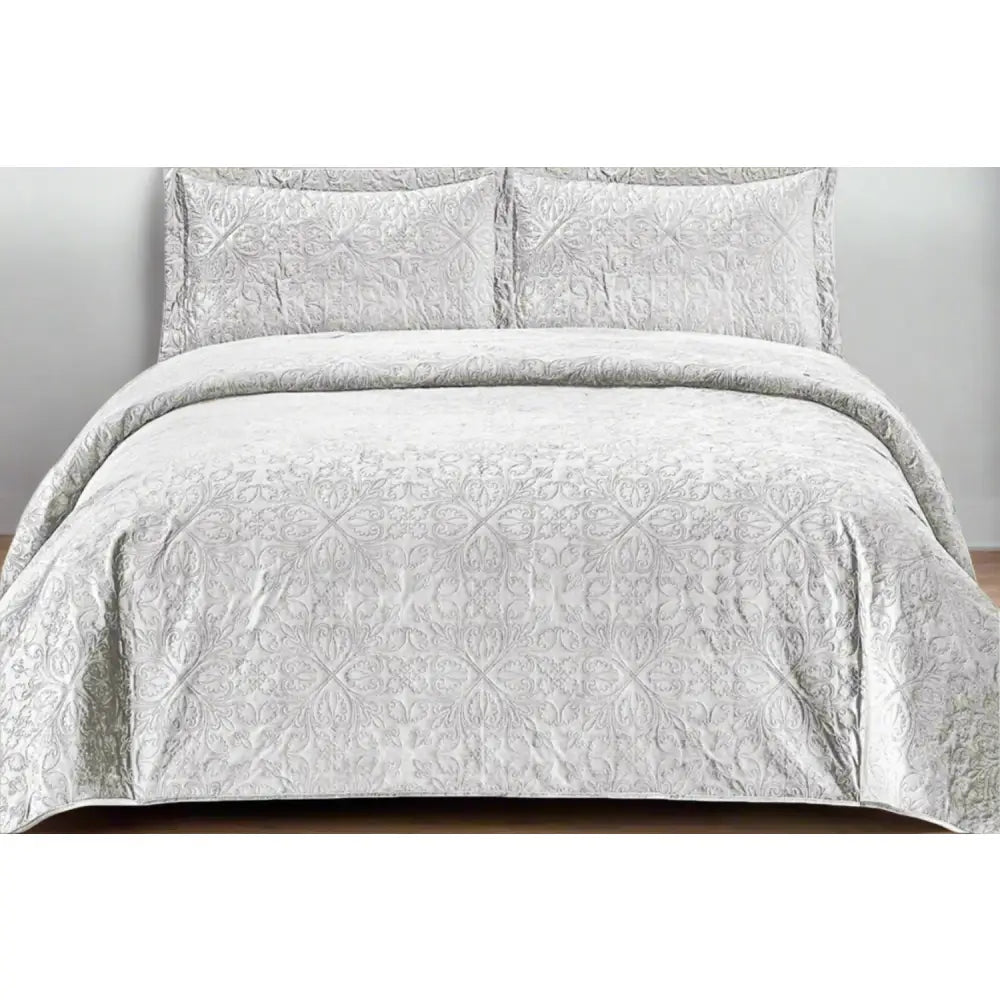 White French velvet quilted bedding set on a bed with matching pillows