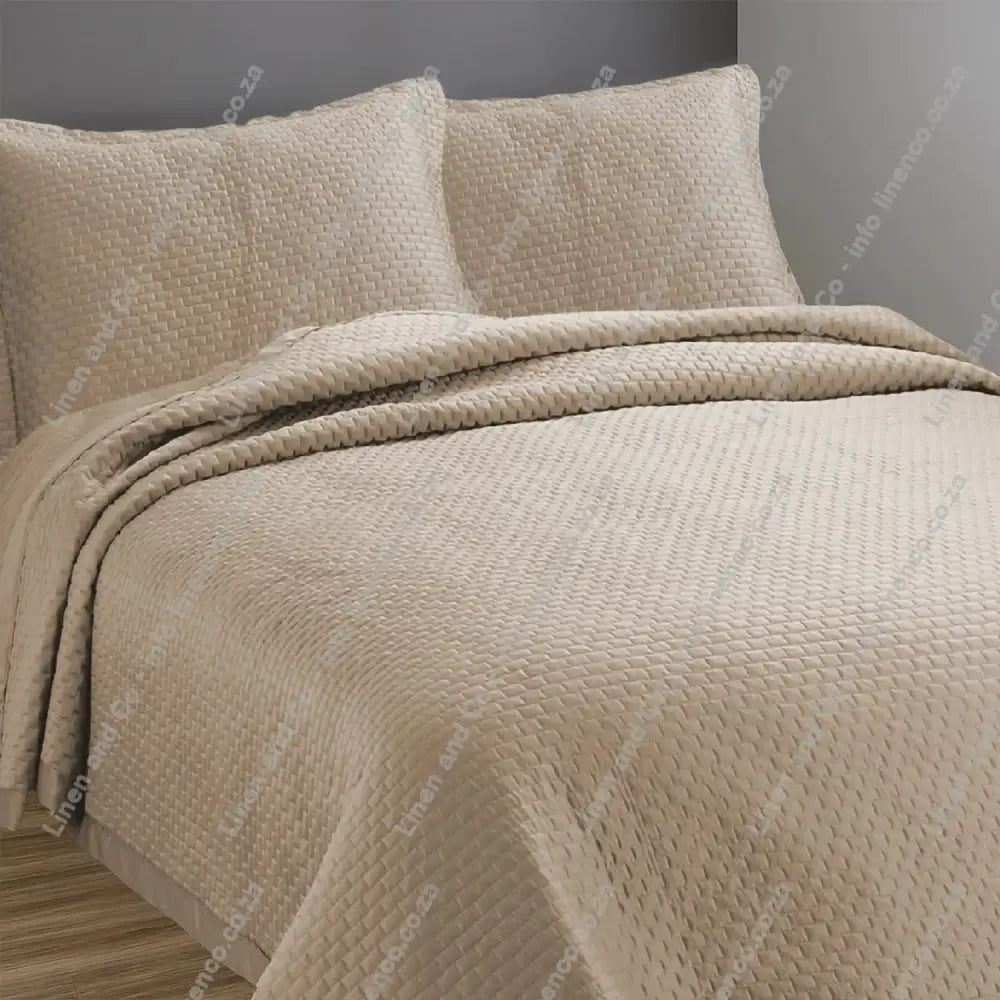 Stone Berlin design quilted bedspread with matching pillow cases on a bed.