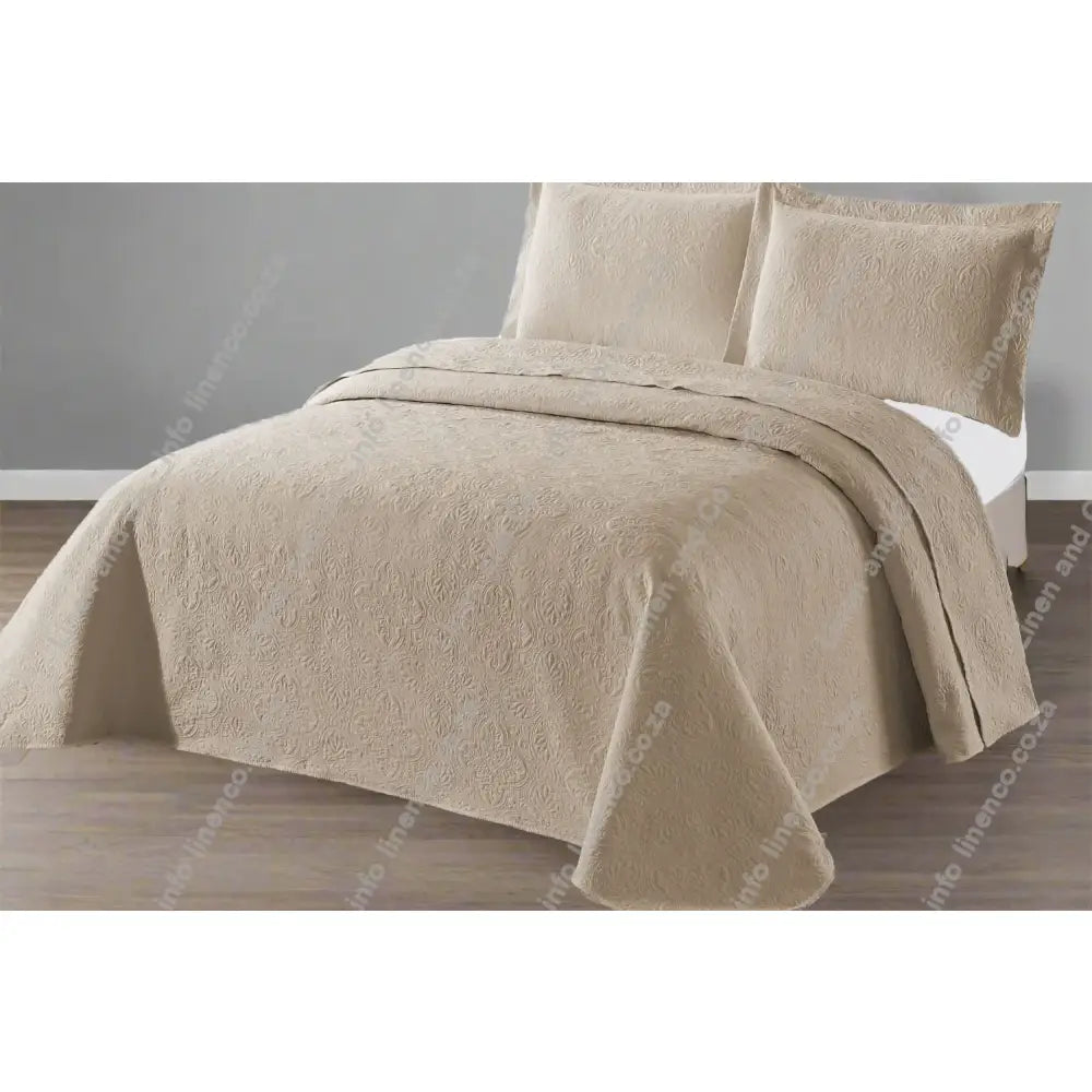 Stone Design Quilted bedspread on a bed with a grey wall background