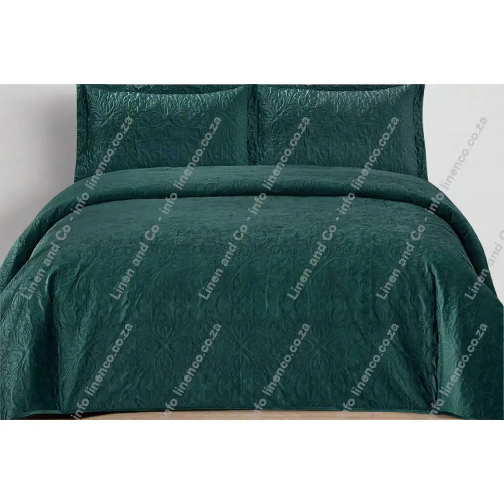 Teal Maroon French velvet quilted bedding set on a bed with matching pillows