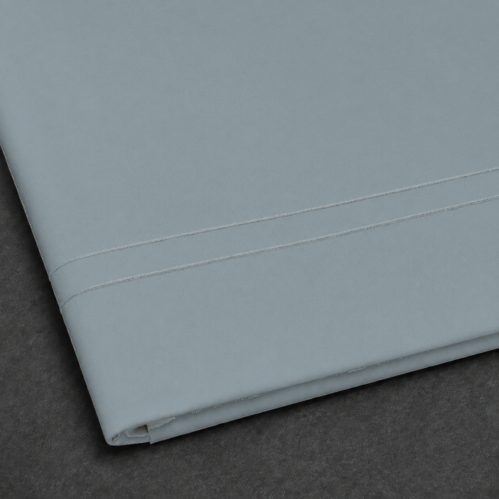 Duck Egg polycotton percale 200TC flat sheet with Natural Cream two-row satin stitch — close-up detail.