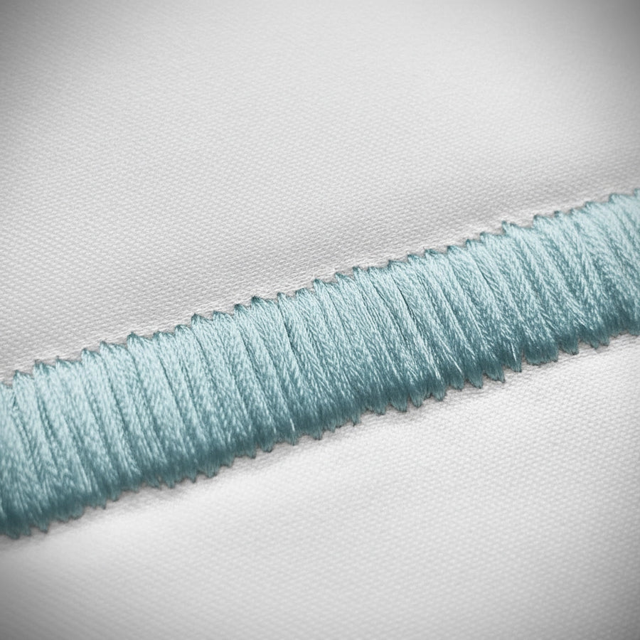 Close-up of duck egg satin stitch detail on white percale by Linen and Co 