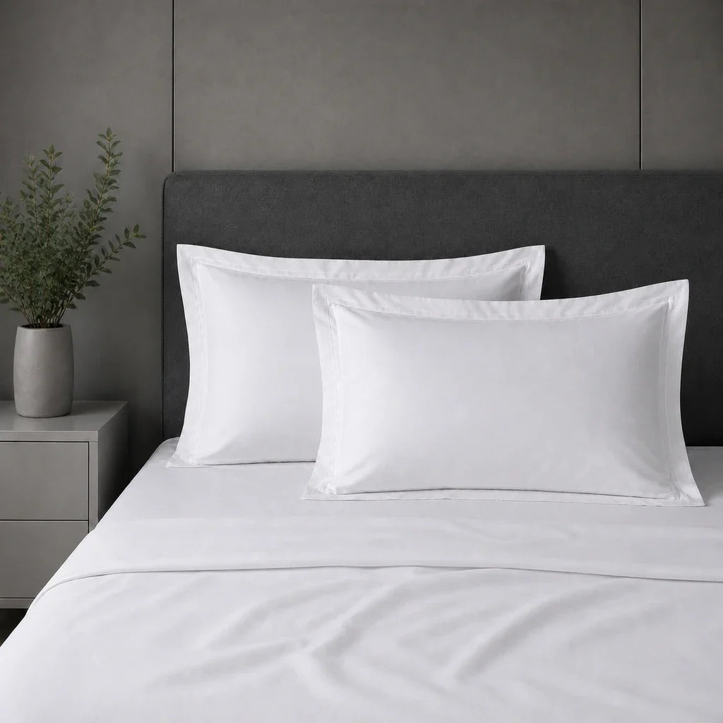 White 100% cotton percale 300TC Oxford pillow cases on a bed with White two-row satin stitch.