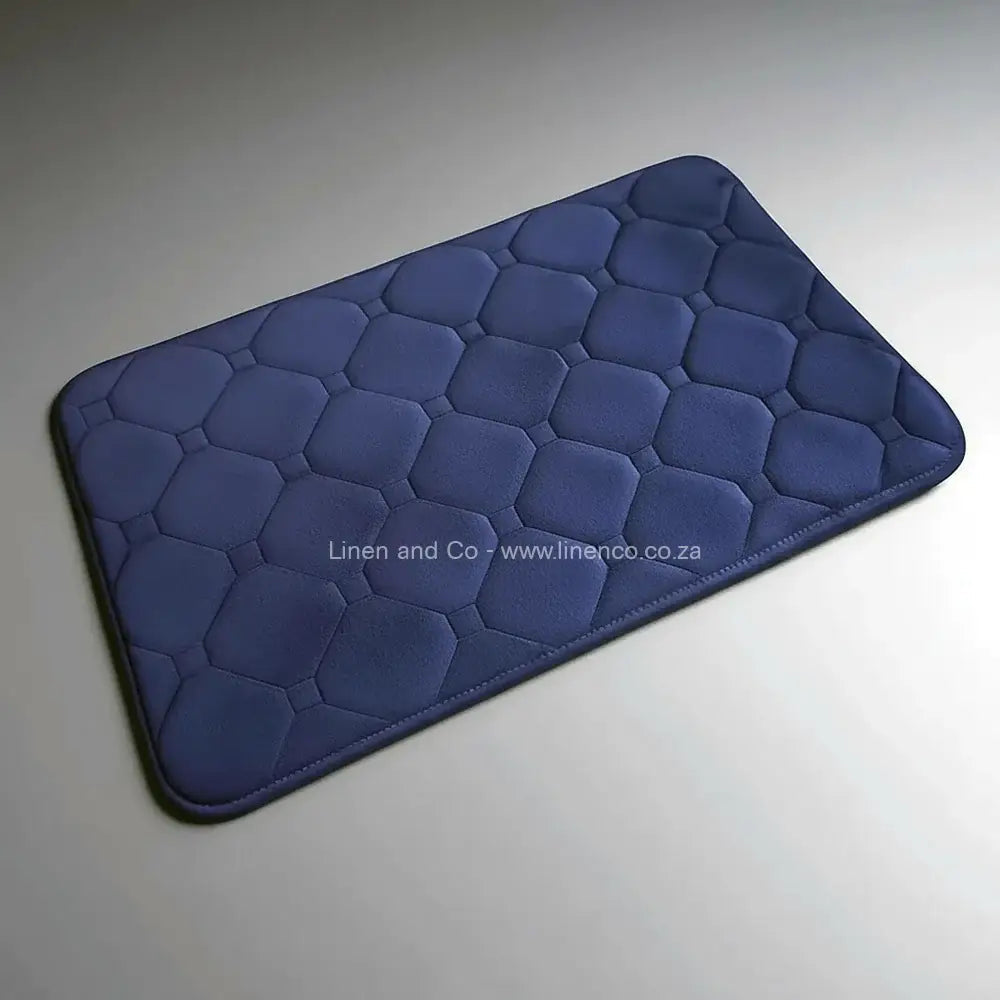 Denim Blue memory foam bath mat by Linen & Co on soft grey gradient background, 50x80cm luxury microfibre bathroom accessory with non-slip backing