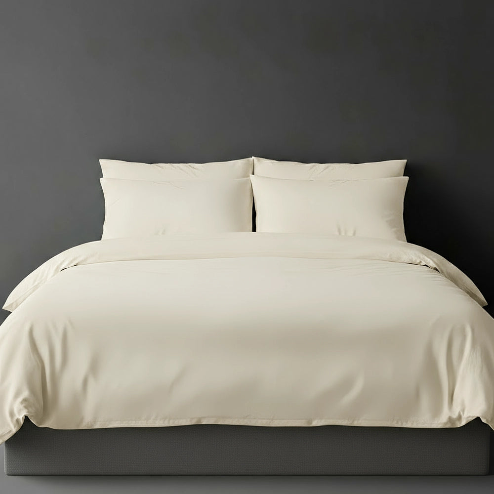Cream plain duvet cover with pillows on bed by Linen and Co - luxury hospitality bed linen
