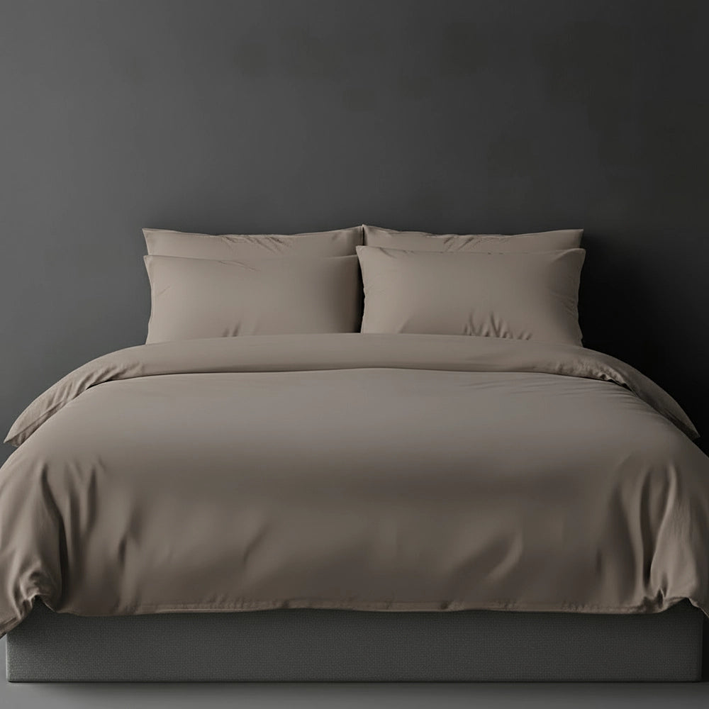 Stone plain duvet cover with pillows on bed by Linen and Co - luxury hospitality bed linen