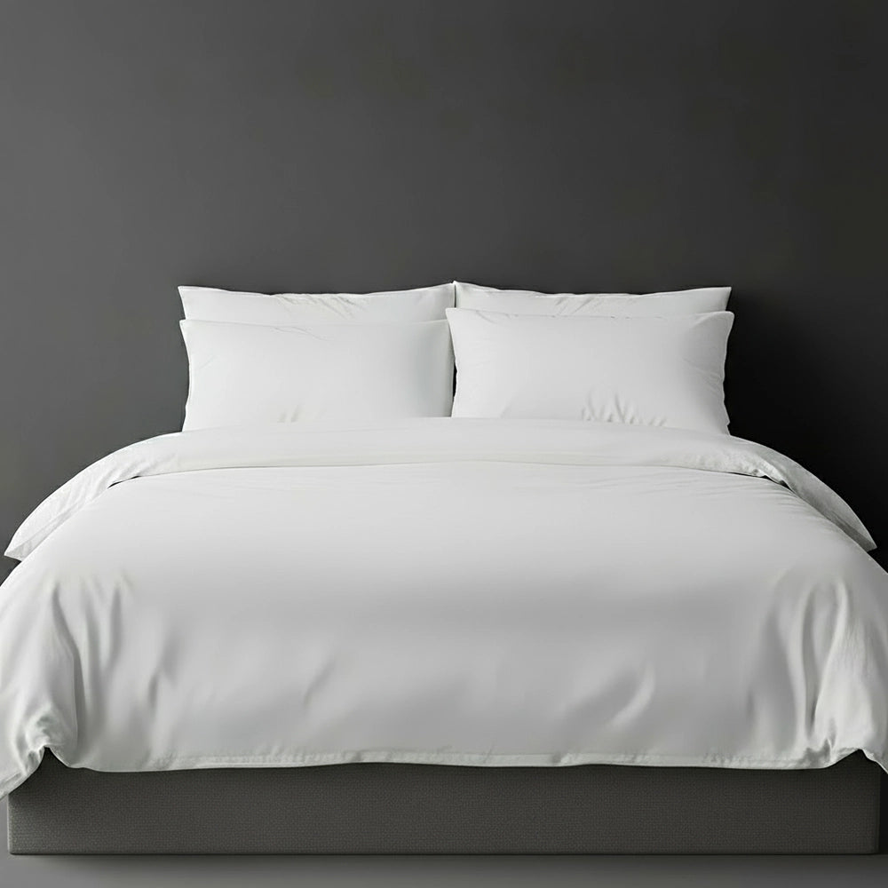 White plain duvet cover with pillows on bed by Linen and Co - luxury hospitality bed linen