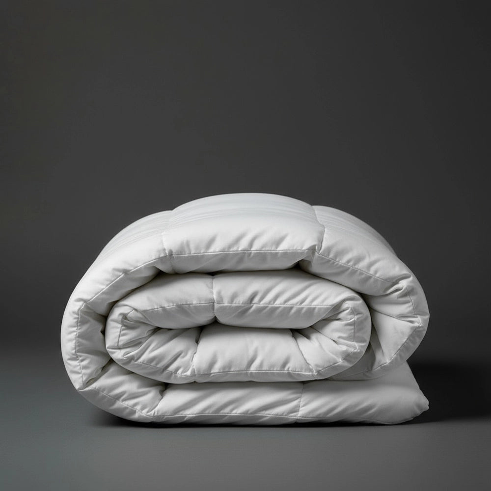 Folded white Hungarian goose down duvet inner on dark grey background—premium luxury down comforter by Linen & Co