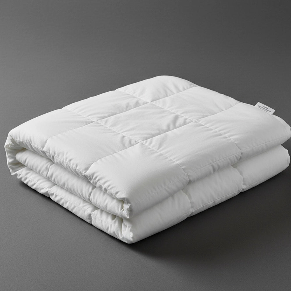 Folded white natural cotton summer duvet inner on dark grey background—lightweight, breathable cotton duvet by Linen & Co