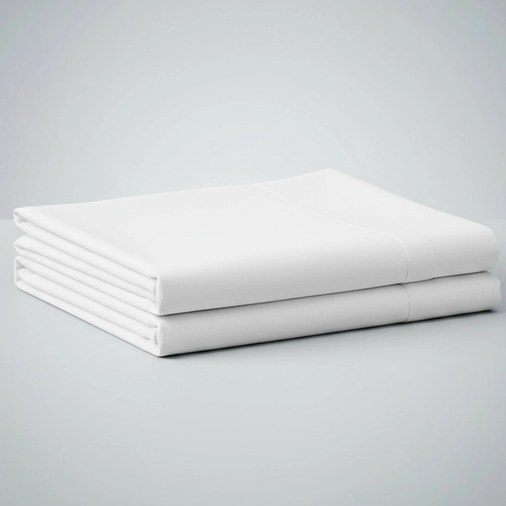 Stack of neatly folded white premium cotton and polycotton percale flat sheets displayed on light grey background—luxury hotel flat sheets by Linen & Co for hospitality and residential use