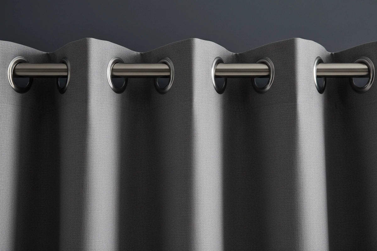 Close-up of grey blockout curtains with silver steel eyelet header on stainless steel rod, showcasing texture and premium hospitality quality.