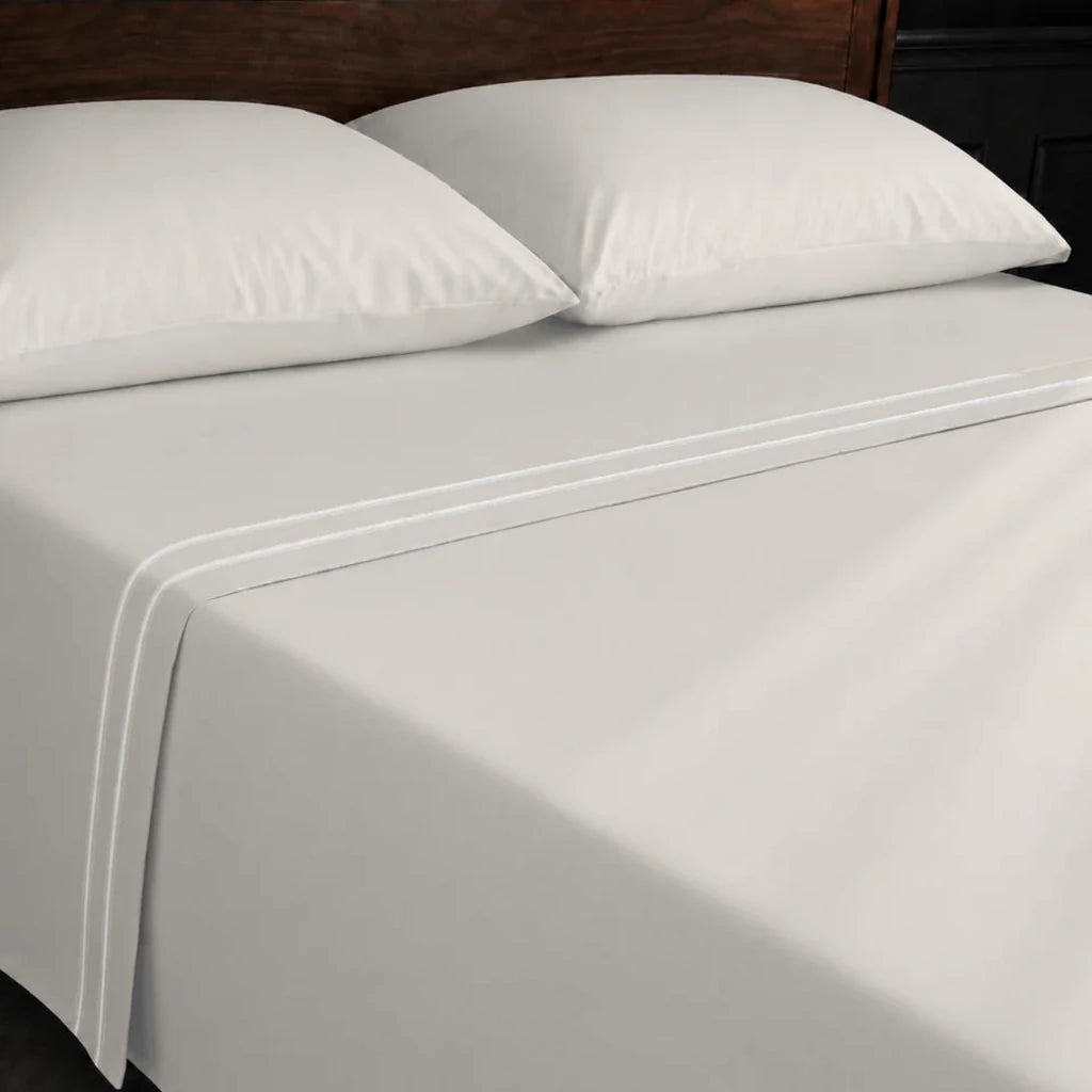 Ivory Cream 100% Cotton Percale 200TC flat sheet with Cream two-row satin stitch - on the bed - Linen and Co