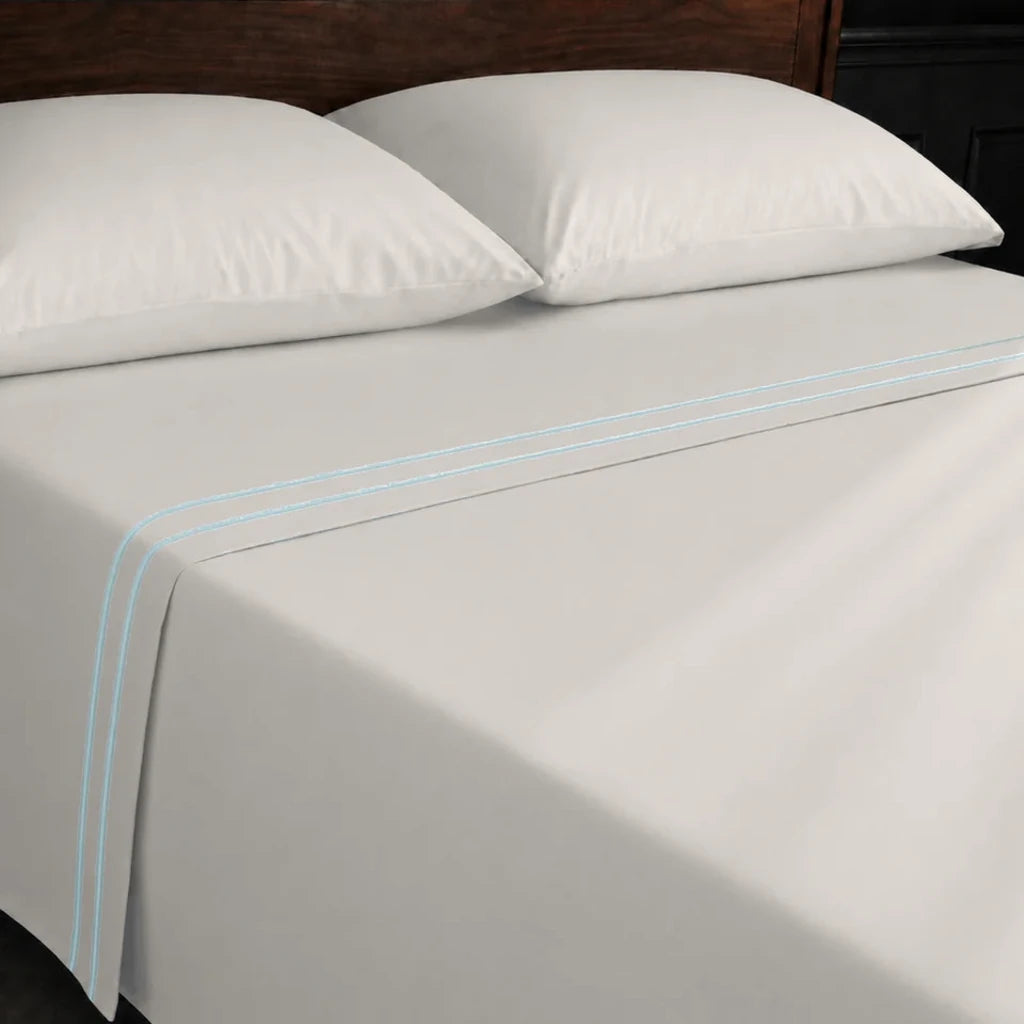 Ivory Cream 100% Cotton Percale 200TC flat sheet with Duck Egg two-row satin stitch - on the bed - Linen and Co