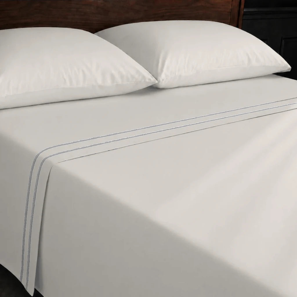 Ivory Cream 100% Cotton Percale 200TC flat sheet with Grey two-row satin stitch - on the bed - Linen and Co