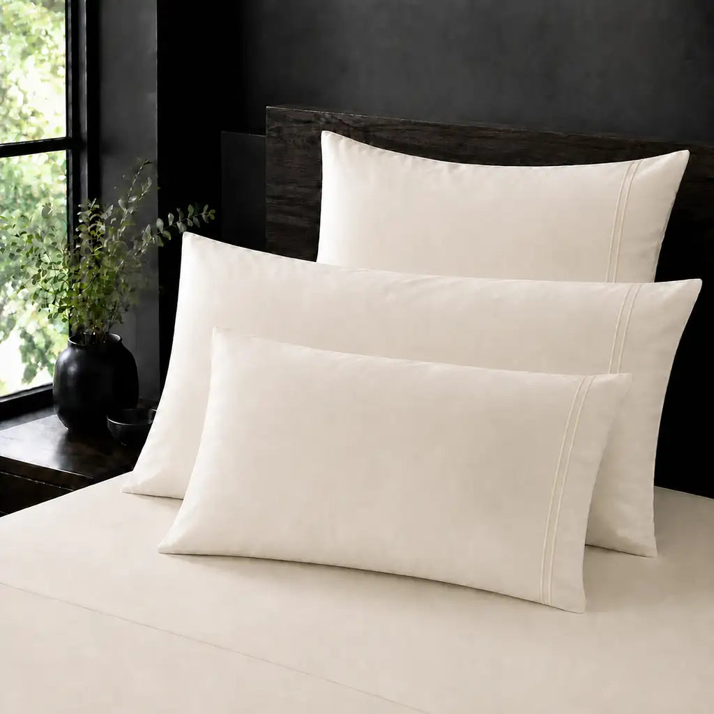 Cream 100% Cotton Percale 200TC plain pillow cases with Cream two-row satin stitch - on the bed - Linen and Co