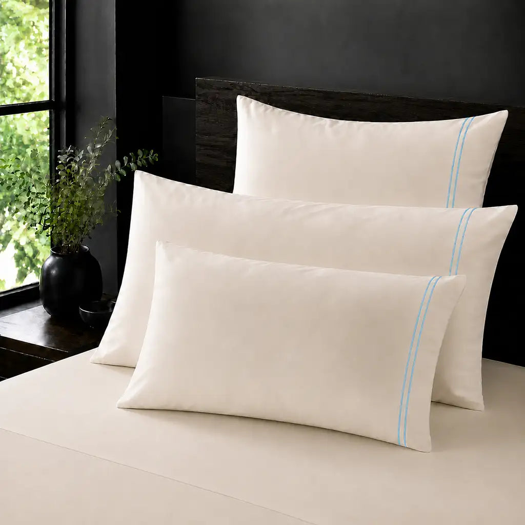 Cream 100% Cotton Percale 200TC plain pillow cases with Duck Egg two-row satin stitch - on the bed - Linen and Co