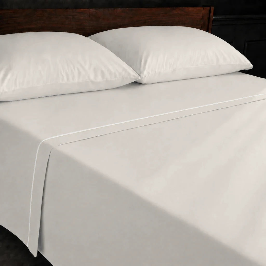 Ivory Cream Polycotton Percale 200TC flat sheet with Cream one-row satin stitch - on the bed - Linen and Co