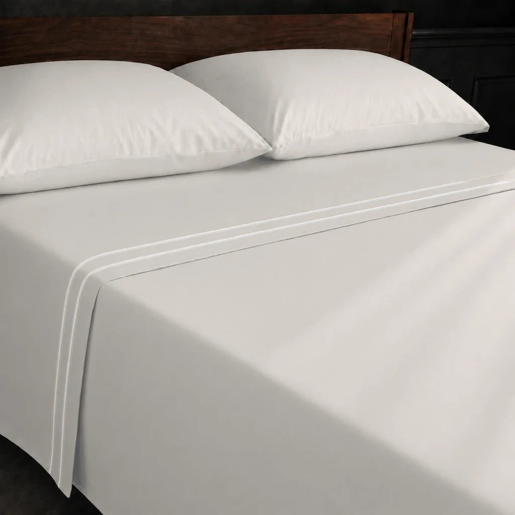 Ivory Cream Polycotton Percale 200TC flat sheet with Cream two-row satin stitch - on the bed - Linen and Co