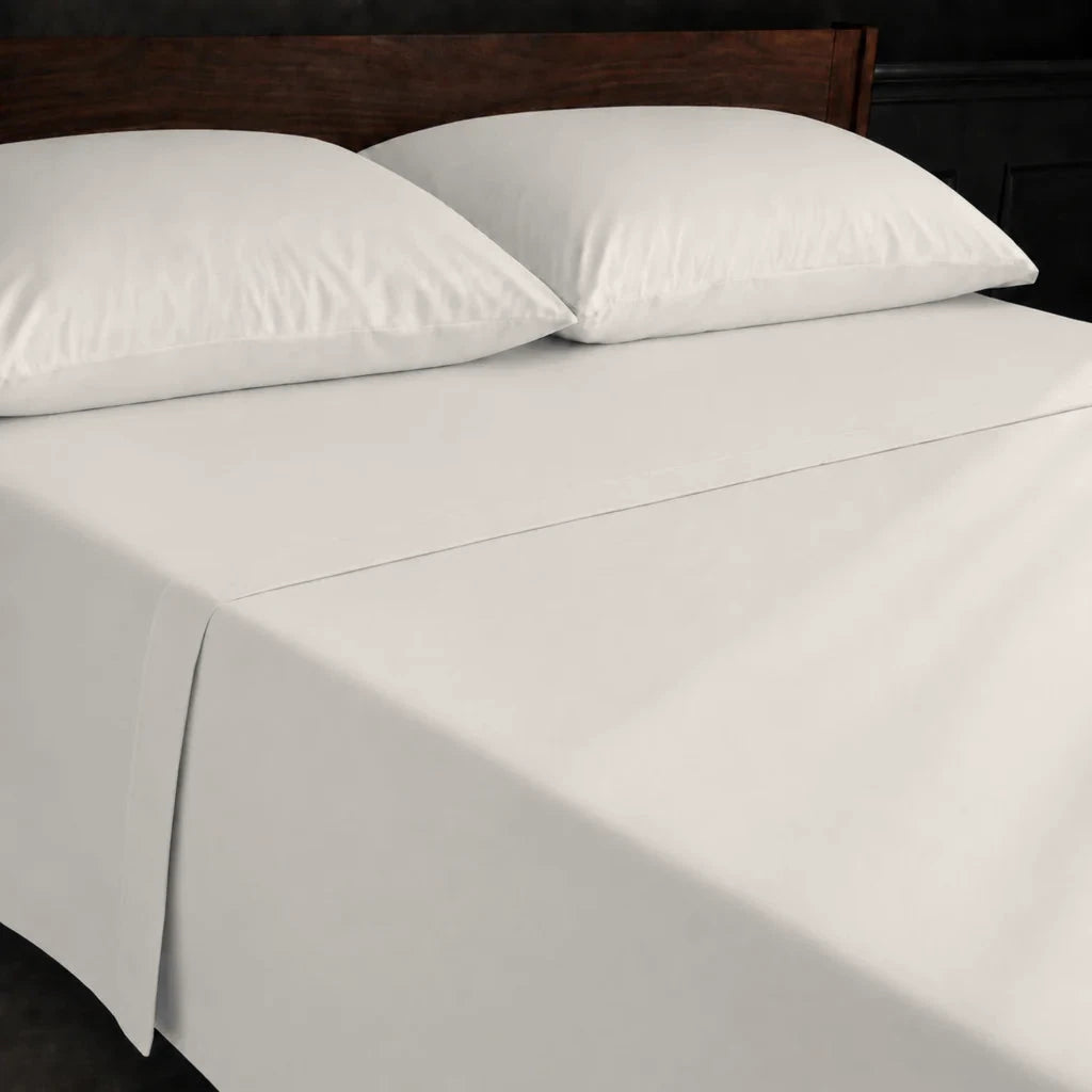 Ivory Cream Polycotton Percale 200TC flat sheet with no satin stitch - on the bed - Linen and Co
