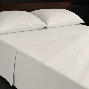Ivory Cream Polycotton Percale 200TC flat sheet with no satin stitch - on the bed - Linen and Co