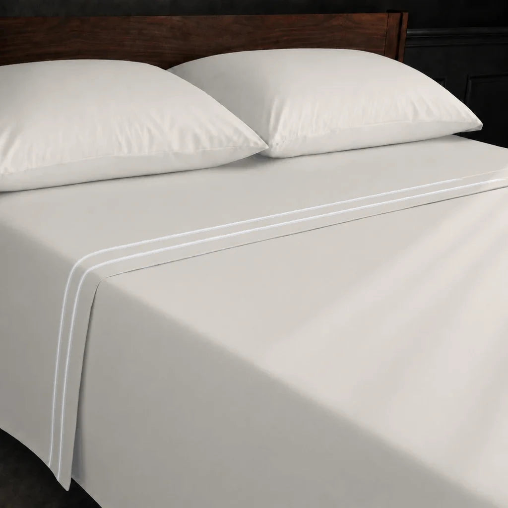 Ivory Cream Polycotton Percale 200TC flat sheet with White two-row satin stitch - on the bed - Linen and Co