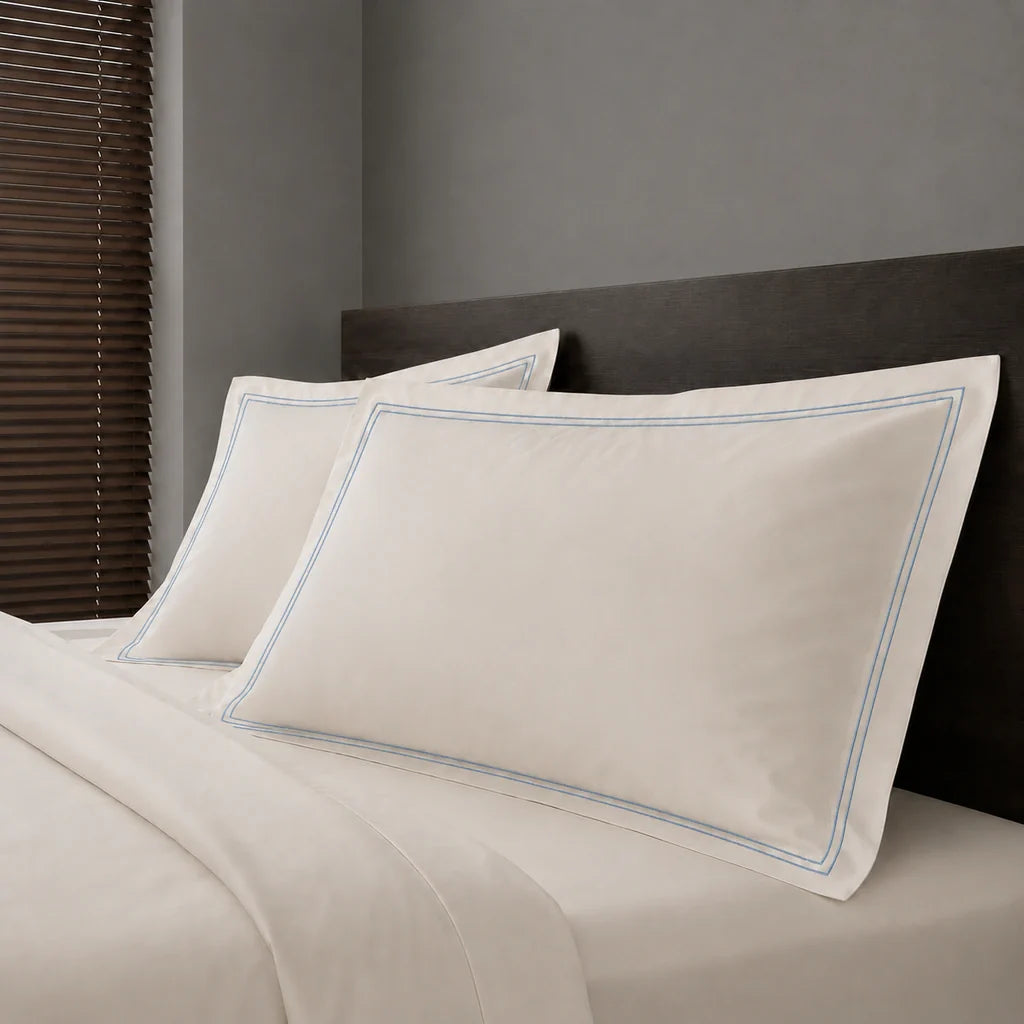 Ivory Cream Polycotton Percale 200TC Oxford pillow cases on a bed with Duck Egg two-row satin stitch - Linen and Co