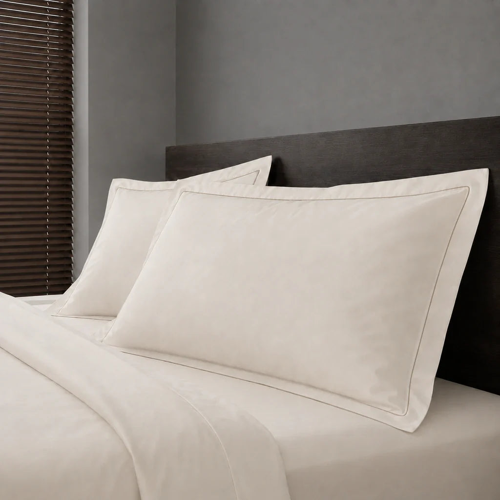 Ivory Cream Polycotton Percale 200TC Oxford pillow cases on a bed with Stone one-row satin stitch - Linen and Co