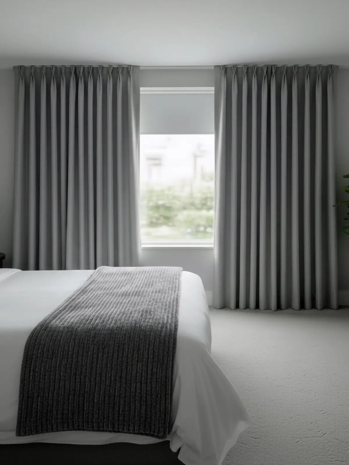 Grey hotel curtains with a white roller blind