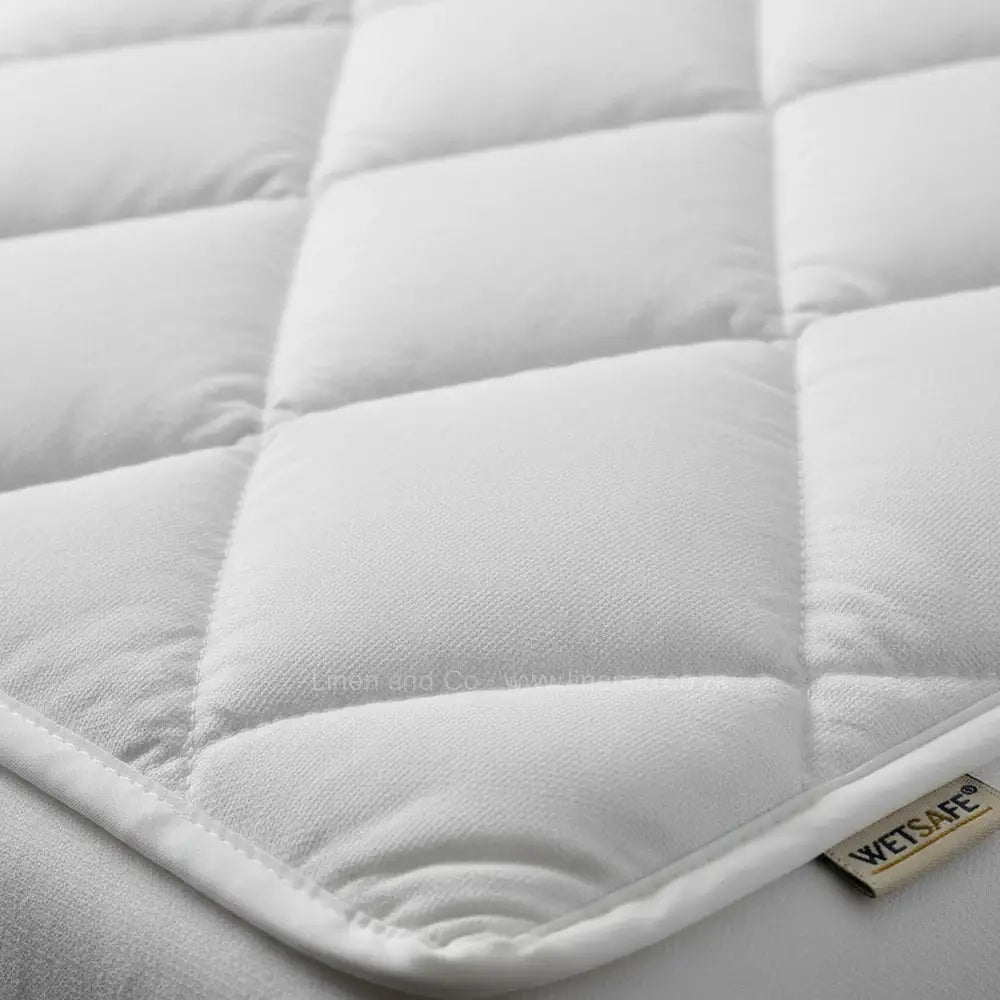 White quilted Wetsafe mattress protector close-up showing box-stitch quilting and waterproof construction - Linen and Co