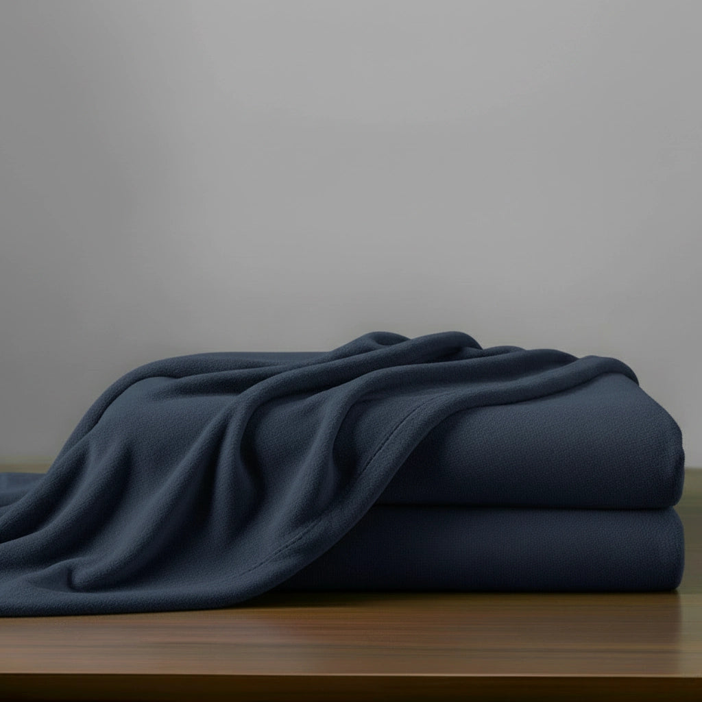 Navy microfibre blanket by Linen and Co, neatly folded to showcase soft, plush texture for hospitality and home.