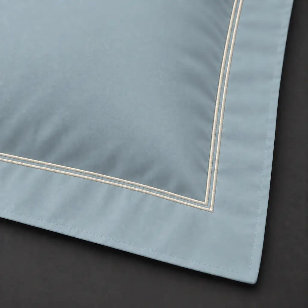Close-up of duck egg Oxford pillowcase with two row cream satin stitch border by Linen and Co