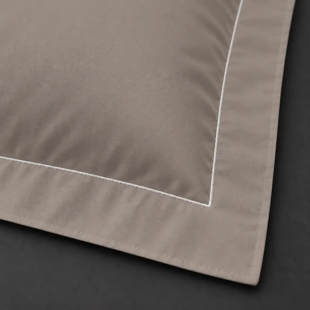 Close-up of stone Oxford pillowcase with one row white satin stitch border by Linen and Co