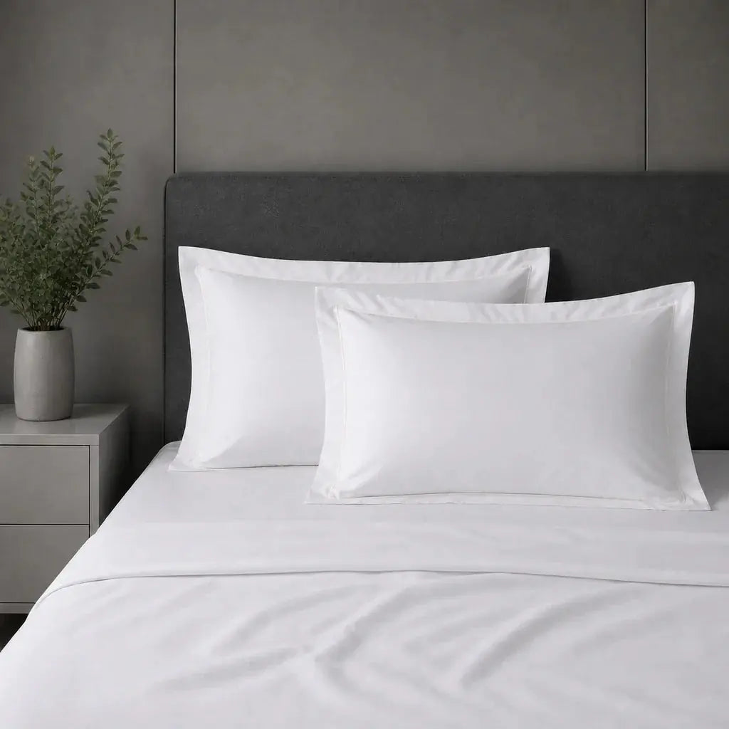 White polycotton percale 200TC Oxford pillow cases on a bed with Cream one-row satin stitch.
