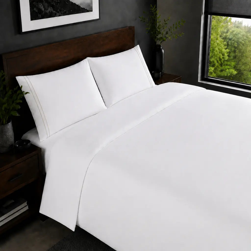 White 200TC plain duvet cover with Cream two row satin stitch - on the bed - Linen and Co