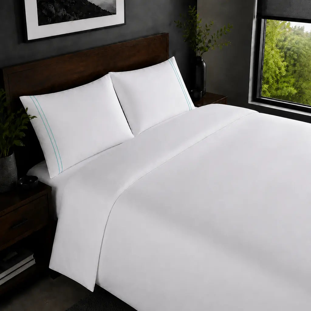 White 200TC plain duvet cover with Duck Egg two row satin stitch - on the bed - Linen and Co