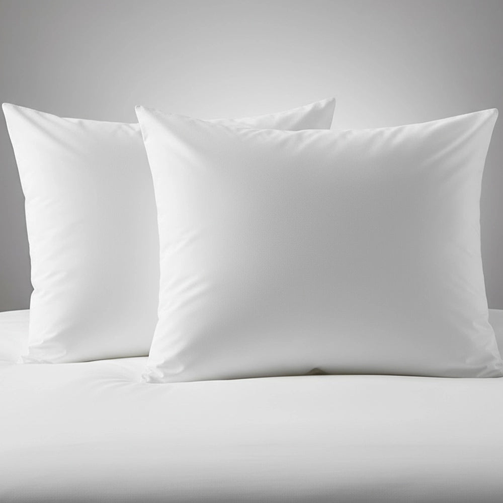 Two white duck feather pillows displayed on neutral grey background, showcasing affordable luxury hospitality-grade bedding by Linen & Co