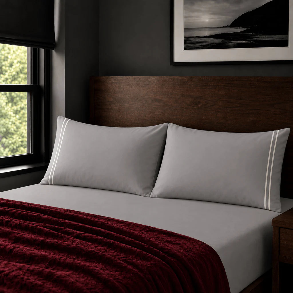 Plain grey 200TC polycotton percale pillowcases with two row cream satin stitch border by Linen and Co