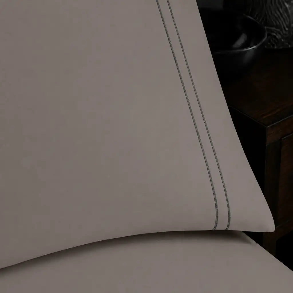 Close-up of stone pillowcase with two row grey satin stitch border by Linen and Co