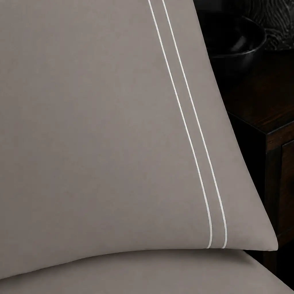 Close-up of stone pillowcase with two row white satin stitch border by Linen and Co