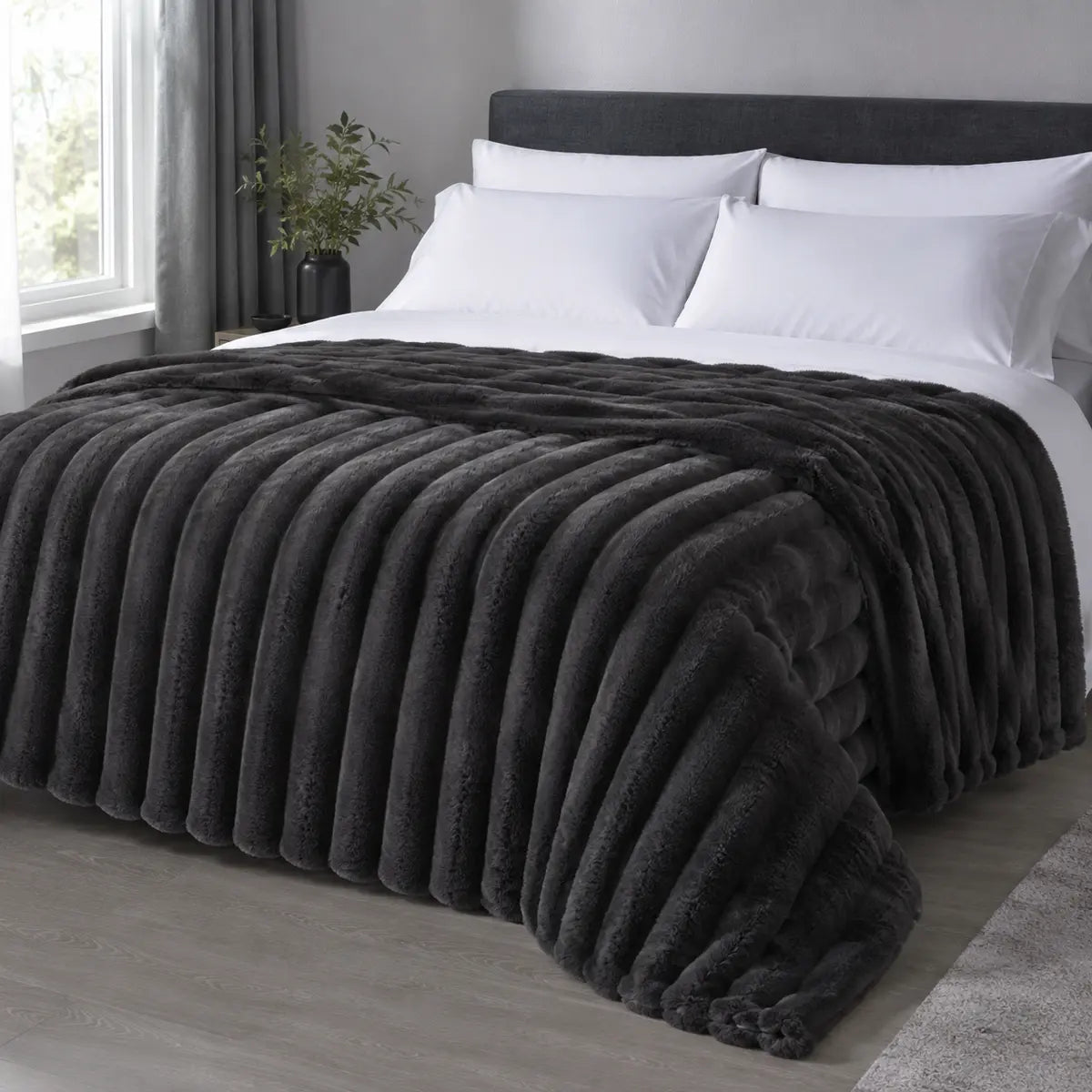 Charcoal ribbed faux fur blanket draped over a bed